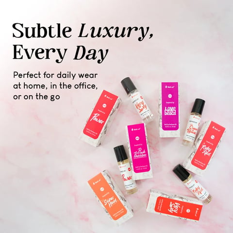 Collection of colorful perfume and fragrance bottles arranged on a marble surface with text Subtle Luxury, Every Day and tagline about daily wear